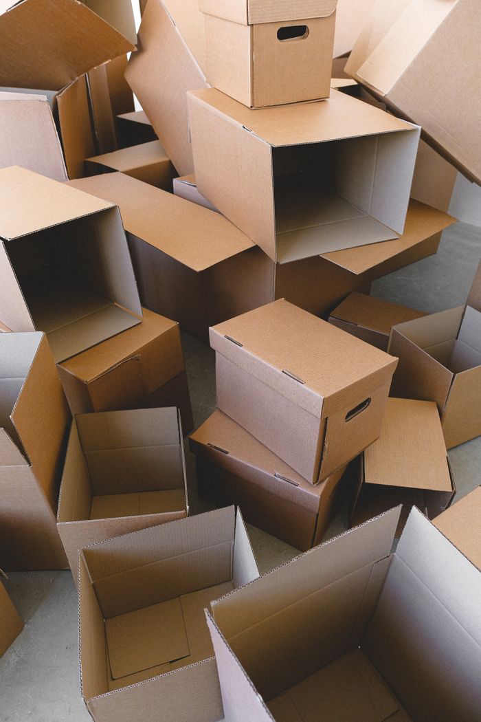 From above of floor with pile of empty carton containers prepared for moving into new house